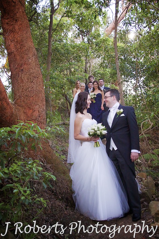 Bride and groom with bridal party in the background on the bush track near Gunners' Barracks - wedding photography sydney